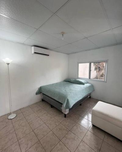 Un dormitorio con una cama y una lámpara. en El Chalet del Canche en Iztapa