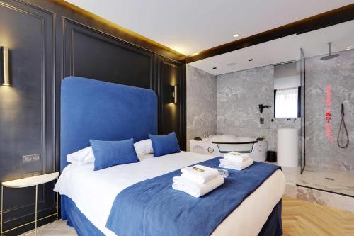 a bedroom with a large bed with towels on it at Couples Getaway Unit with Jacuzzi - City Center in Paris