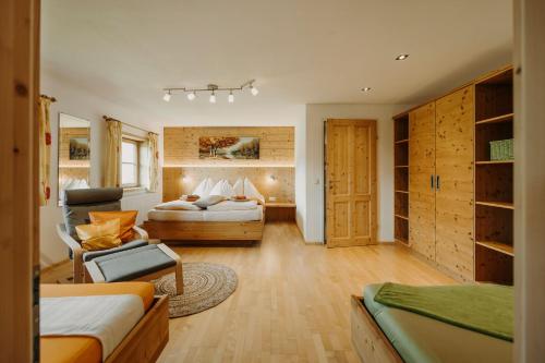 a bedroom with two beds and a couch and a chair at Bauernhof Unterbichl in Flachau