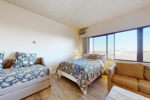 大洋城的住宿－Highpoint North M1，一间卧室设有两张床、一张沙发和一个窗口