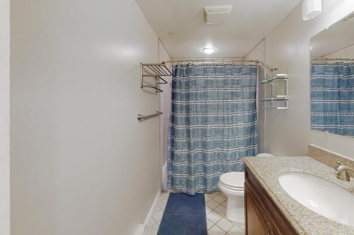 uma casa de banho com uma cortina de chuveiro azul e um WC. em Highpoint North M1 em Ocean City