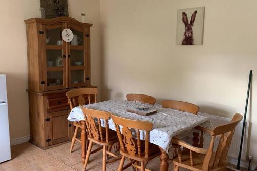 d'une salle à manger avec une table, des chaises et un réfrigérateur. dans l'établissement Bumblebee Cottage, à Donegal