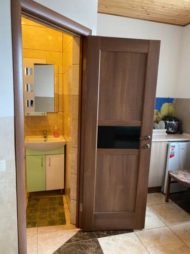 een badkamer met een houten deur en een wastafel bij Домашній Затишок in Stryi