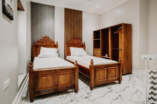 2 Einzelbetten in einem Zimmer mit weißen Wänden in der Unterkunft Najma's villa in Stone Town