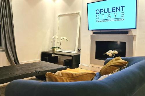 salon z niebieską kanapą i telewizorem z płaskim ekranem w obiekcie Stunning Luxury 2 Bed Penthouse Apartment w mieście Derby