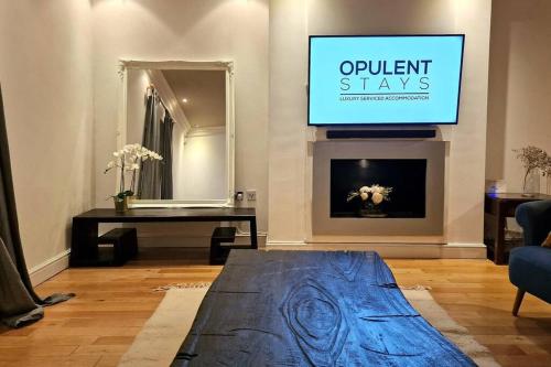 a living room with a tv and a couch and a fireplace at Stunning Luxury 2 Bed Penthouse Apartment in Derby