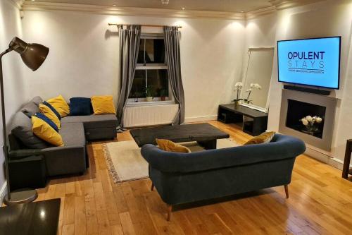 a living room with a couch and a tv at Stunning Luxury 2 Bed Penthouse Apartment in Derby