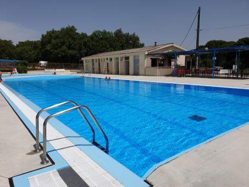 Limogne-en-QuercyCAMPING LE BEL AIR mobil home LE CORNOUILLER 4 personnes的一个蓝色海水的大型游泳池