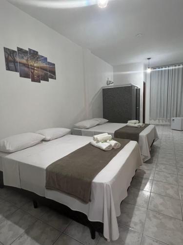 a bedroom with two beds and a tv at Pousada Styllus da Serra in Miguel Pereira