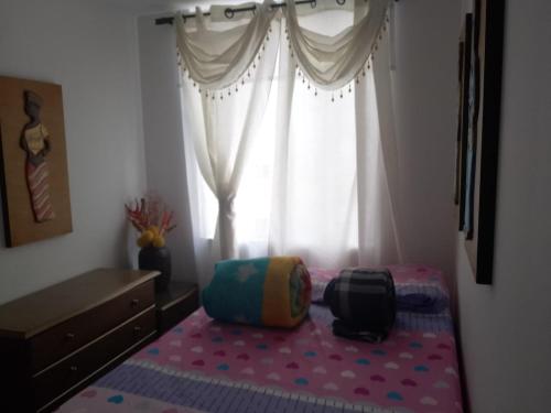 1 dormitorio con cama y ventana en CIBELES ARMENIA APARTAMENTO AMOBLADo, en Armenia