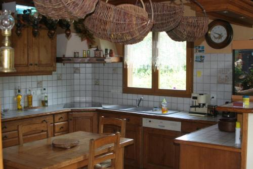 a kitchen with wooden cabinets and a table and a window at Chambre d'hôtes "LES CRETS" in Mercury