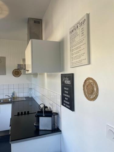 a kitchen with a refrigerator and a sign on the wall at Home Cassis - Maison Les Calanques - Piscine chauffée à 30c in Cassis