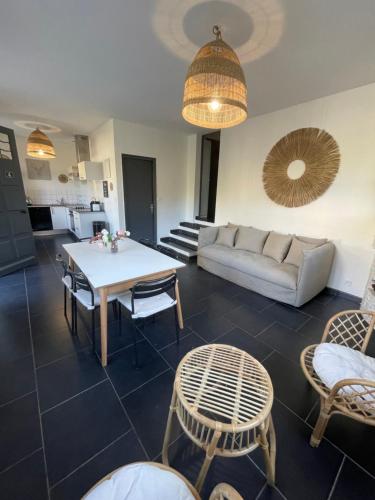 a living room with a couch and a table and chairs at Home Cassis - Maison Les Calanques - Piscine chauffée à 30c in Cassis