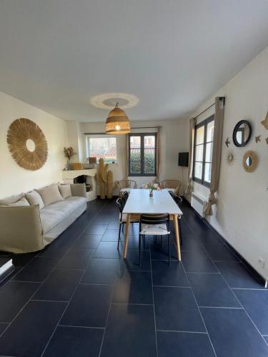a living room with a couch and a table at Home Cassis - Maison Les Calanques - Piscine chauffée à 30c in Cassis