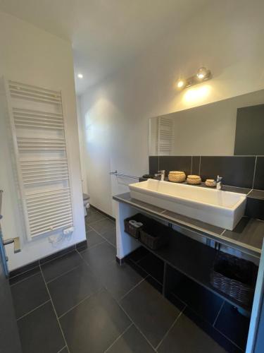 Home Cassis - Maison Les Calanques - Piscine chauffée في كاسيس: حمام مع حوض ومرآة كبيرة