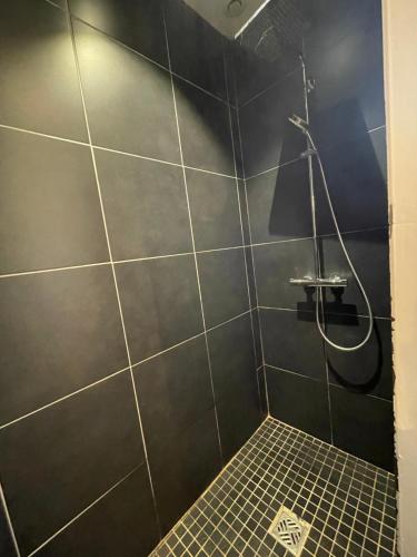 a bathroom with a shower with a black wall at Home Cassis - Maison Les Calanques - Piscine chauffée à 30c in Cassis