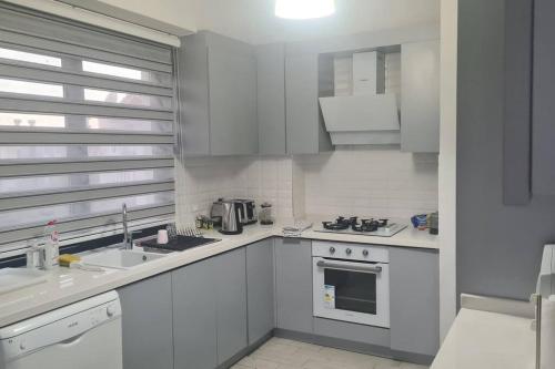 a white kitchen with a sink and a stove at Mountainview residency in Belek
