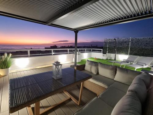 patio con sofá y mesa en el balcón en Ático Los Flamingos. Exclusive terrace with views en Cabo de Gata