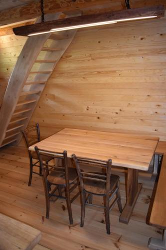 a wooden table and chairs in a log cabin at Glamping Organic Farm Slibar in Tržič