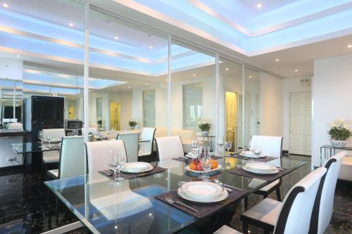 a dining room with a glass table and chairs at PATONG TOWER SEA VIEW for FAMILY's by PATONG TOWER AGENCY in Patong Beach