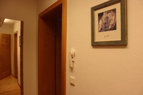 a picture hanging on a wall next to a phone at Landhaus-Appartements Warraich in Schladming
