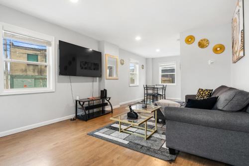 a living room with a couch and a tv at Polished 2-bedroom close to OSU Campus in Columbus