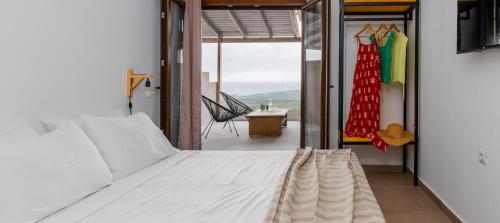 a bedroom with a bed and a view of a balcony at Hilltop Resort at Kefalonia in Angón