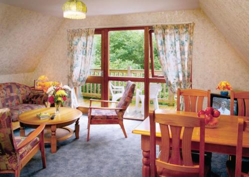 a living room with a table and chairs and a couch at Delny Highland Lodges in Invergordon
