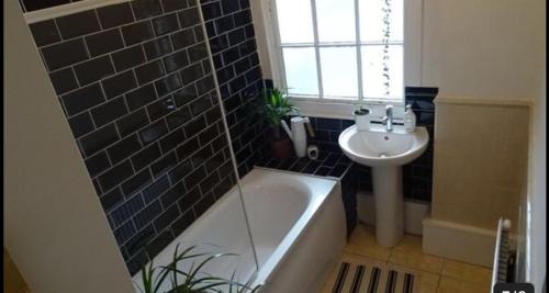 y baño con lavabo y bañera junto a un lavabo. en West gate Street near Stadium Cardiff, en Cardiff