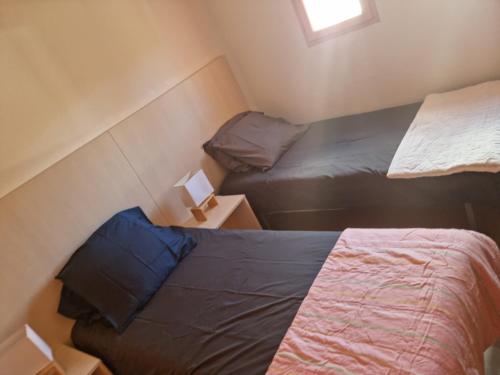 a small bedroom with two beds and a window at Maison de Vancances à louer Alpes Maritimes in Mouans-Sartoux