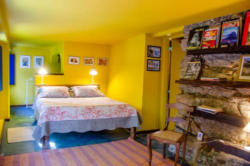 a bedroom with a bed and a stone fireplace at Hospedaria Fazenda São João do Vale da Grama in Visconde De Maua