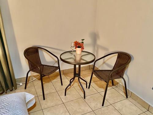 a table with two chairs and a vase on it at daBene Francavilla B&B in Alajuela