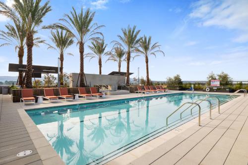 uma piscina com cadeiras e palmeiras em Kasa University-Airport Santa Clara em Santa Clara