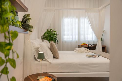 a bedroom with a white bed with a window at Daline Holiday Rooms in Acquarica del Capo