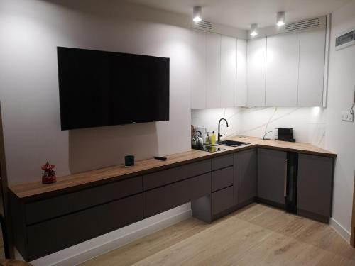 a kitchen with a flat screen tv on the wall at Gold Pearl Zegrze in Serock