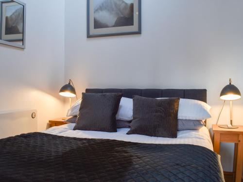 1 dormitorio con 1 cama grande y 2 lámparas en Pear Tree Barn, en Crooklands