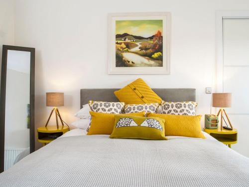 a bedroom with a large bed with yellow pillows at Strathspey Lodge in Duthil