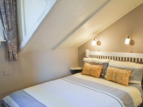a bedroom with a bed with two pillows at Larch Cottage in Craster