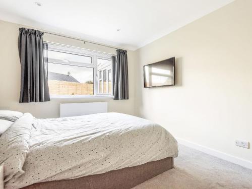 a bedroom with a bed and a window at Church View in Probus