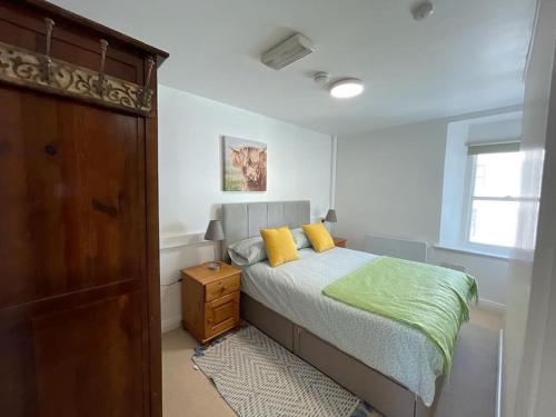 um quarto com uma cama com almofadas amarelas em Westport town centre three bedroom em Mayo