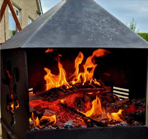 a fire in a grill with flames in it at Annie Dee’s Guest Accommodation in Ballygowan
