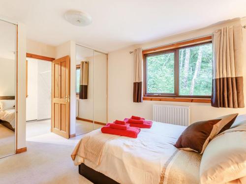 BearnockにあるGlen View Of Enrick Houseのベッドルーム1室(赤い枕が付いた大型ベッド1台付)