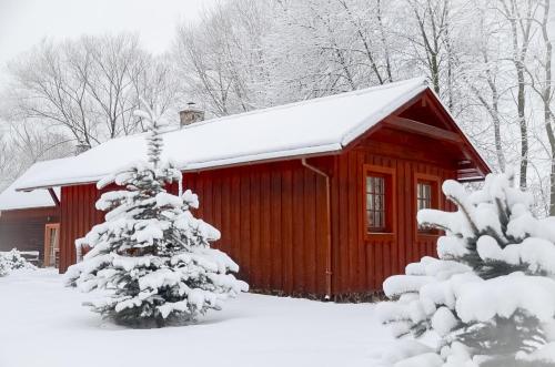 a red cabin with a snow covered roof at Holiday home at Aquapark Tatralandia in Liptovský Mikuláš