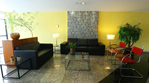 a living room filled with furniture and a large window at Mansoori Apart Hotel II in Brasília