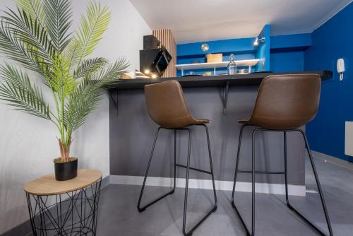 a kitchen with two bar stools and a plant at Solstice T2 Hypercentre SmartTV Wifi in Pamiers