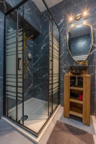 a shower stall with a mirror and a sink at Solstice T2 Hypercentre SmartTV Wifi in Pamiers
