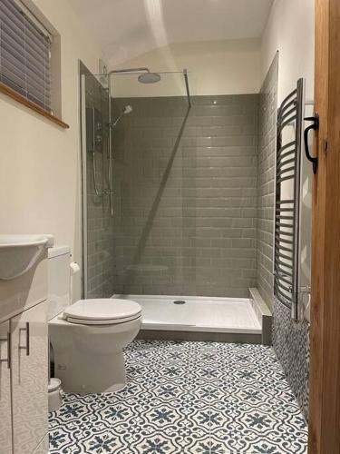 a bathroom with a tub and a toilet and a shower at Beech Cottage in Bodiam