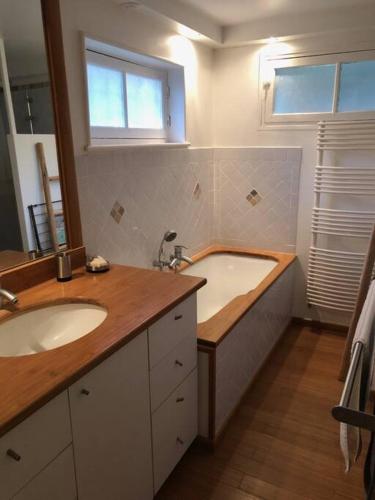 une salle de bain avec deux lavabos et une baignoire dans l'établissement Chez Babeth, à Chaville