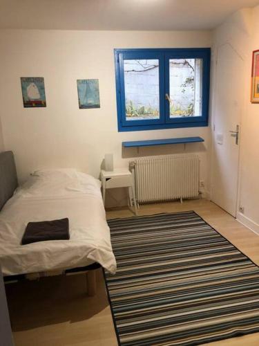 - une chambre avec un lit, une fenêtre et un tapis dans l'établissement Chez Babeth, à Chaville
