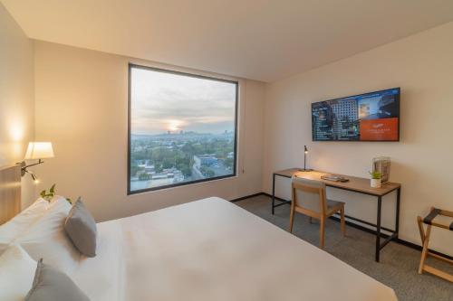 Postel nebo postele na pokoji v ubytování Stadía Suites Querétaro Centro Histórico